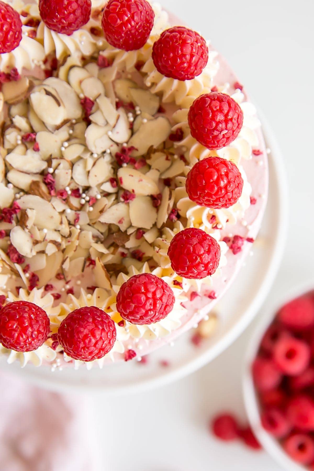 Top view of the cake showing fresh raspberries and almond slices on top.