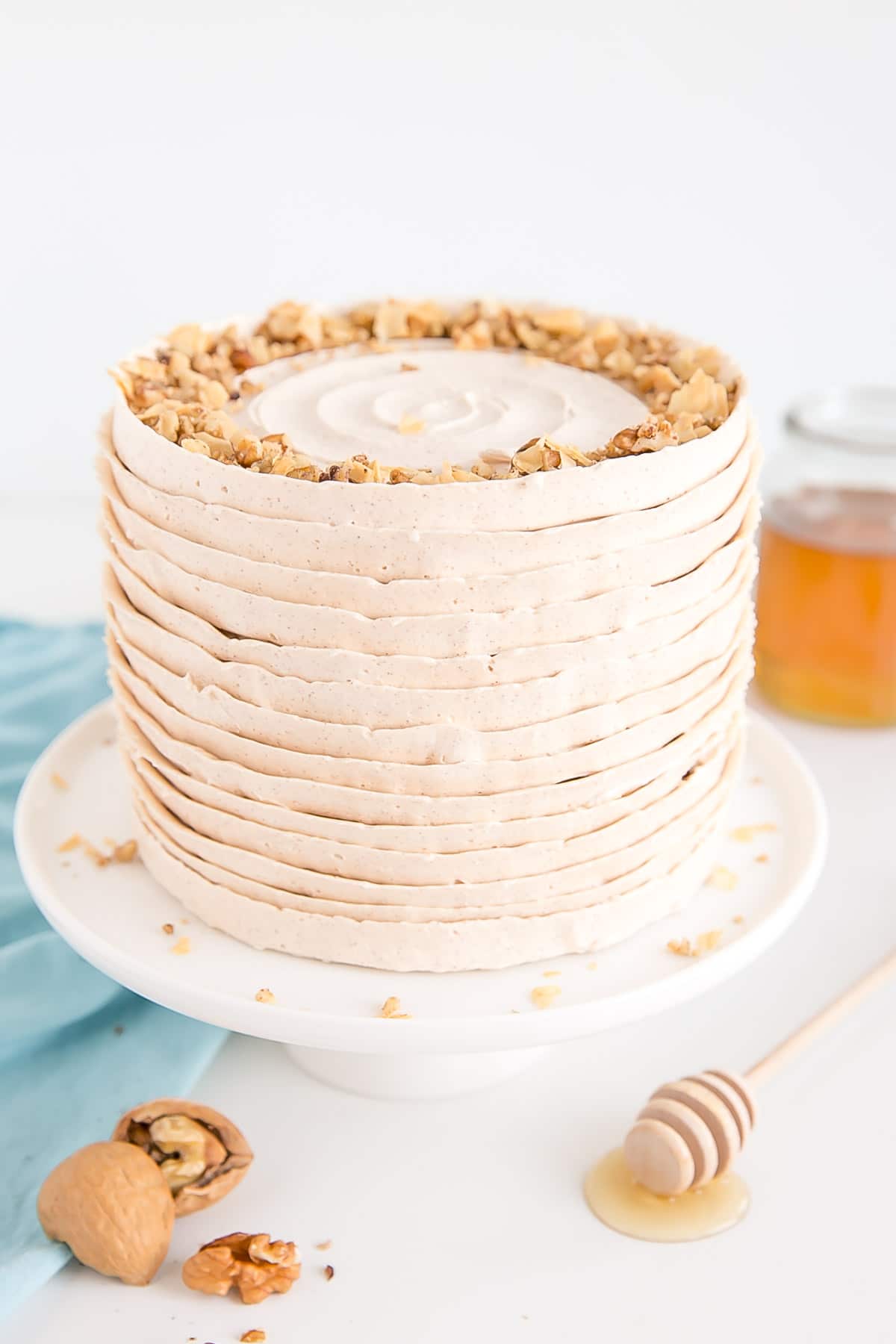 Baklava cake with layers of honey cinnamon frosting and sprinkled with chopped walnuts and baked filo.