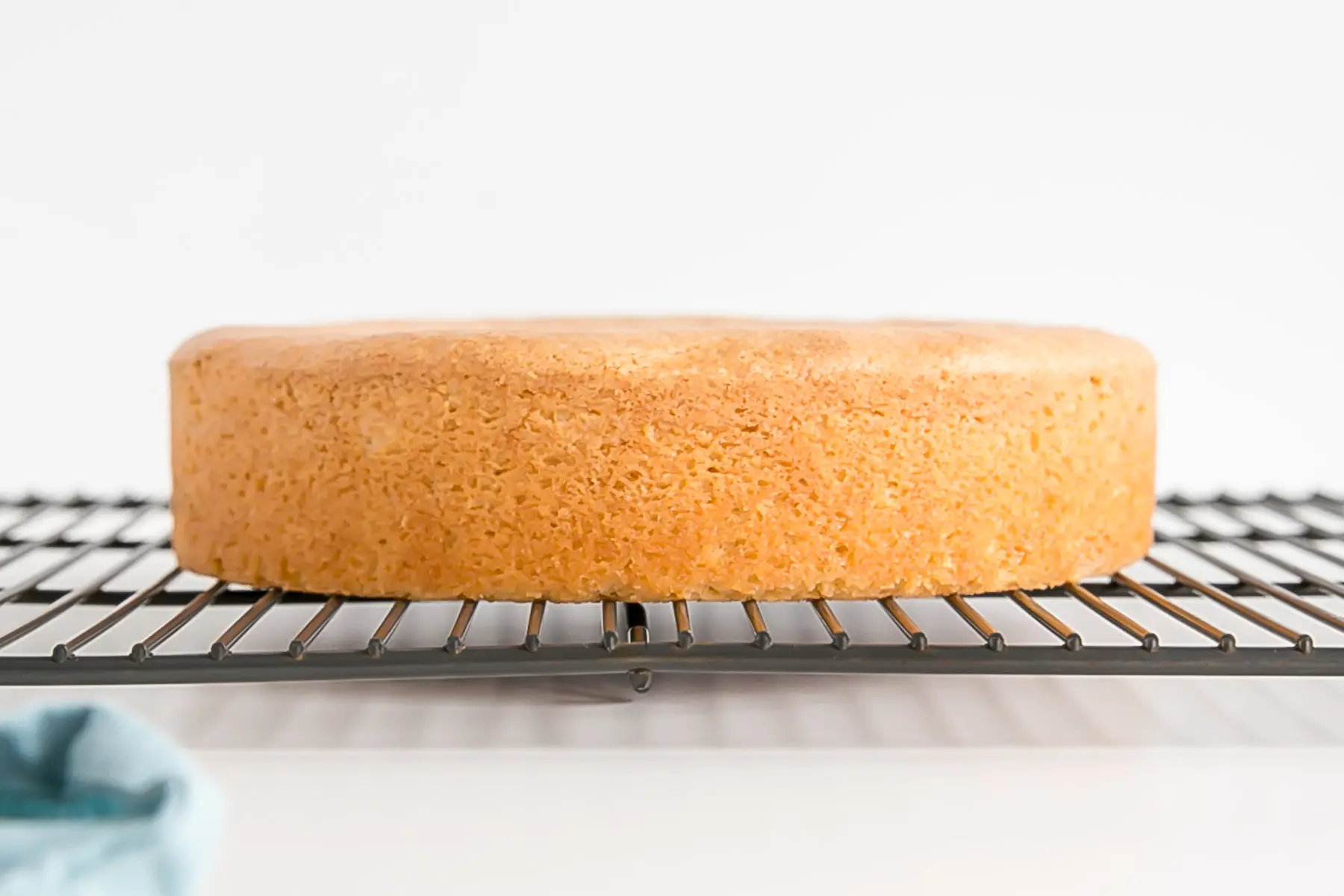 Baked doctored box cake layer on a cooling rack.