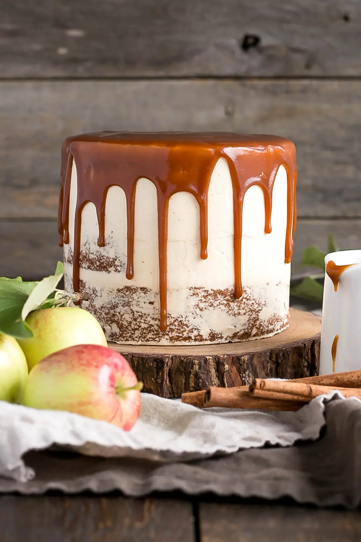 Cake with a caramel drip on a rustic cake stand.