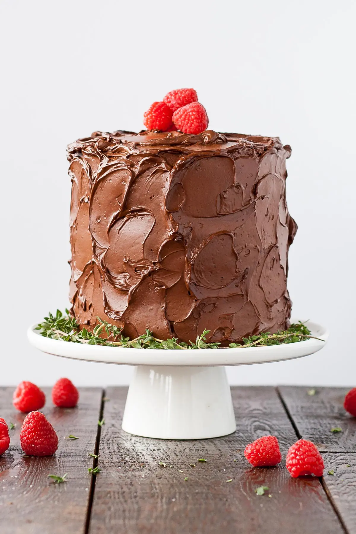 Chocolate cake on a white cake stand.