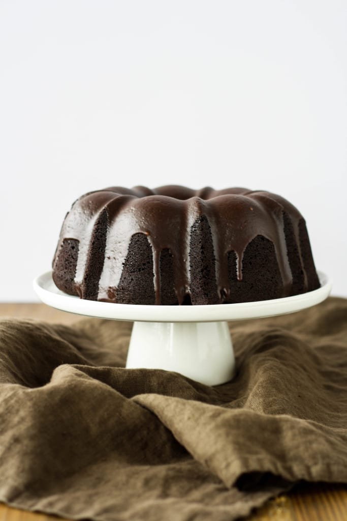 Chocolate Bundt cake on a white cake stand.