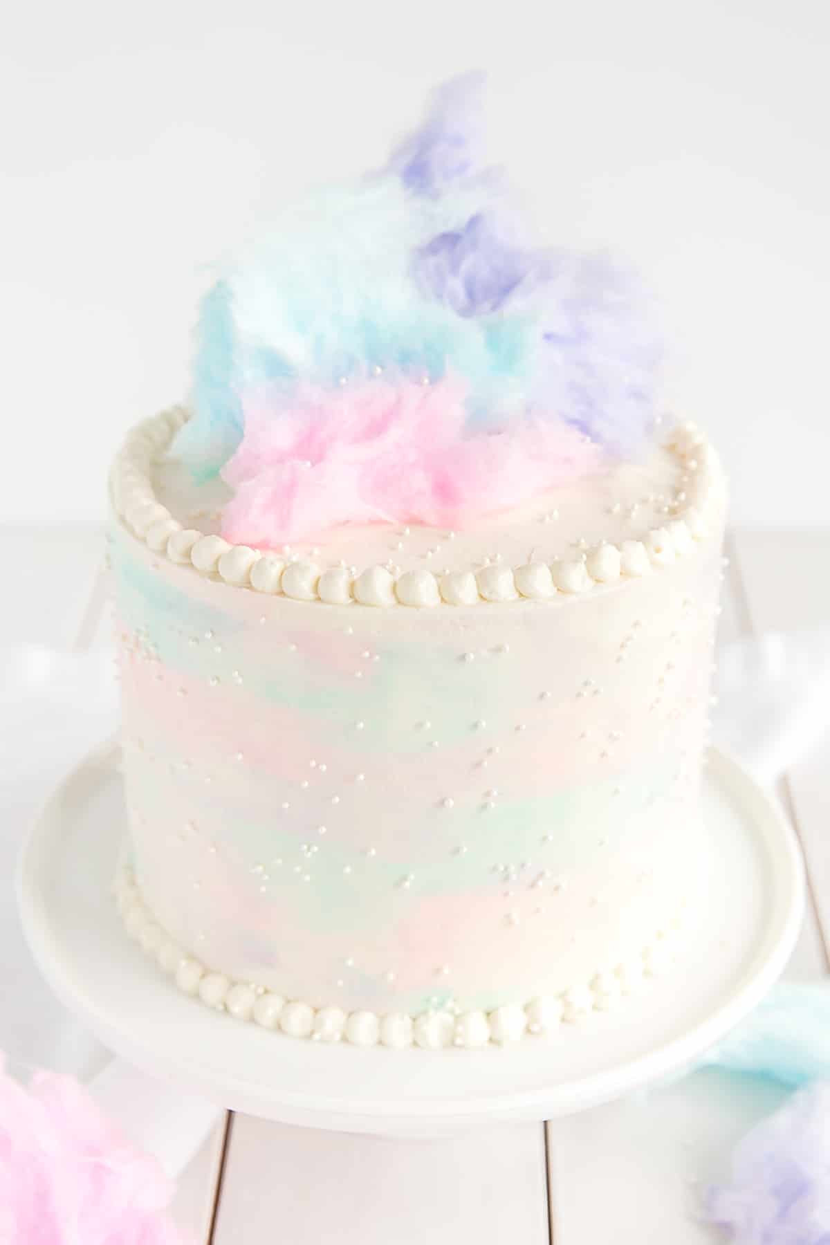 Cotton Candy Cake angled picture showing watercolor sides, pearl border, and cotton candy on top.