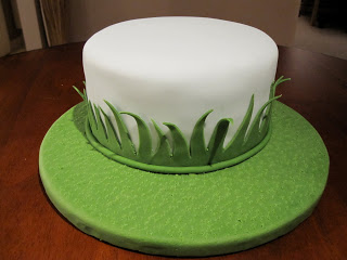 Cake on a green grass fondant covered cake board.