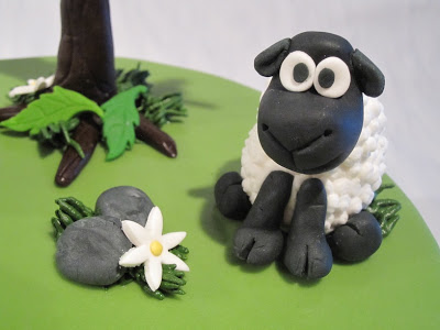 Close up of a fondant sheep on a cake.