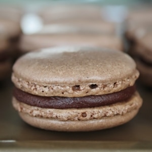 A close up of a chocolate macaron