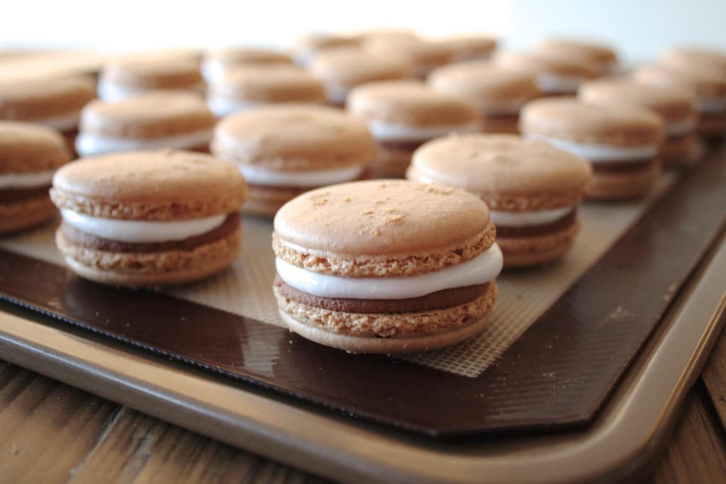 A close up of the filled cookies on a baking sheet.