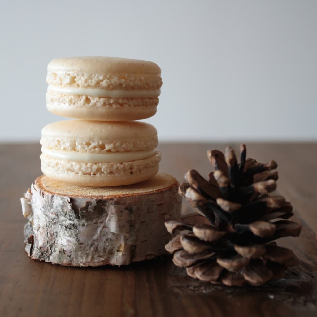 Two eggnog macarons stacked.