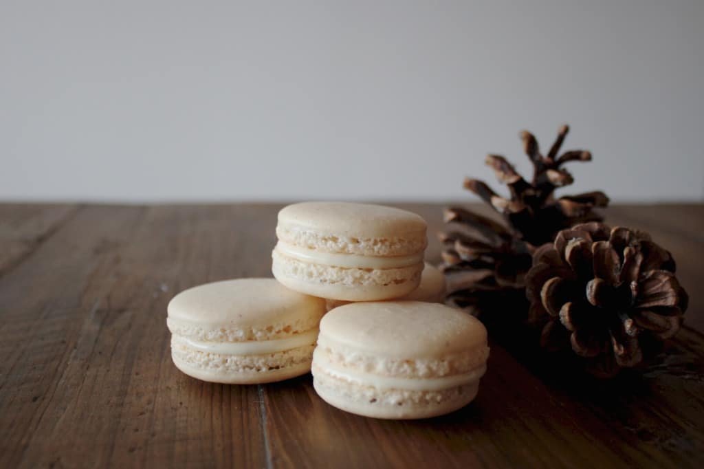 Eggnog macarons on a wood table.