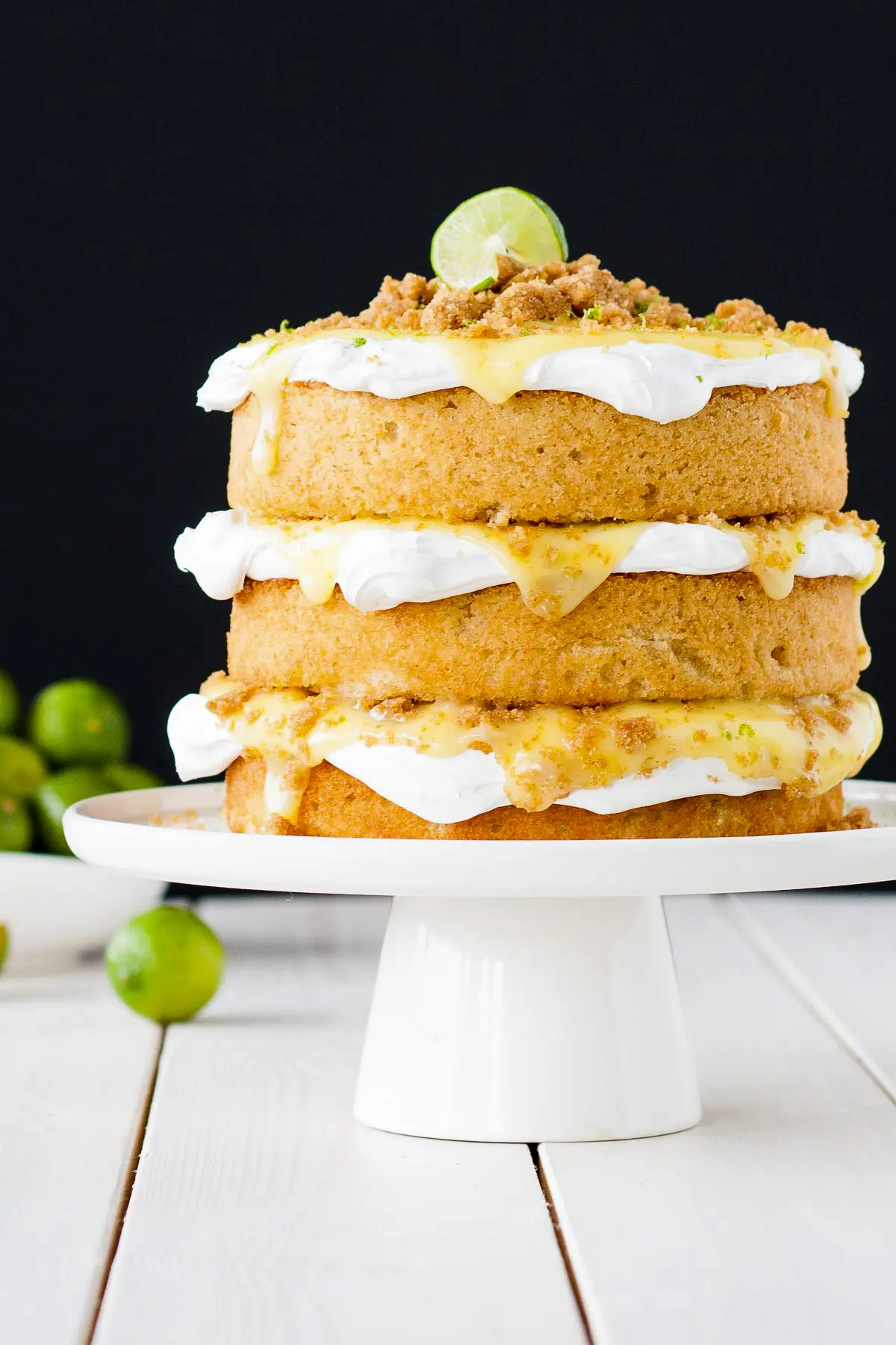 Cake on a white cake stand and a black background.