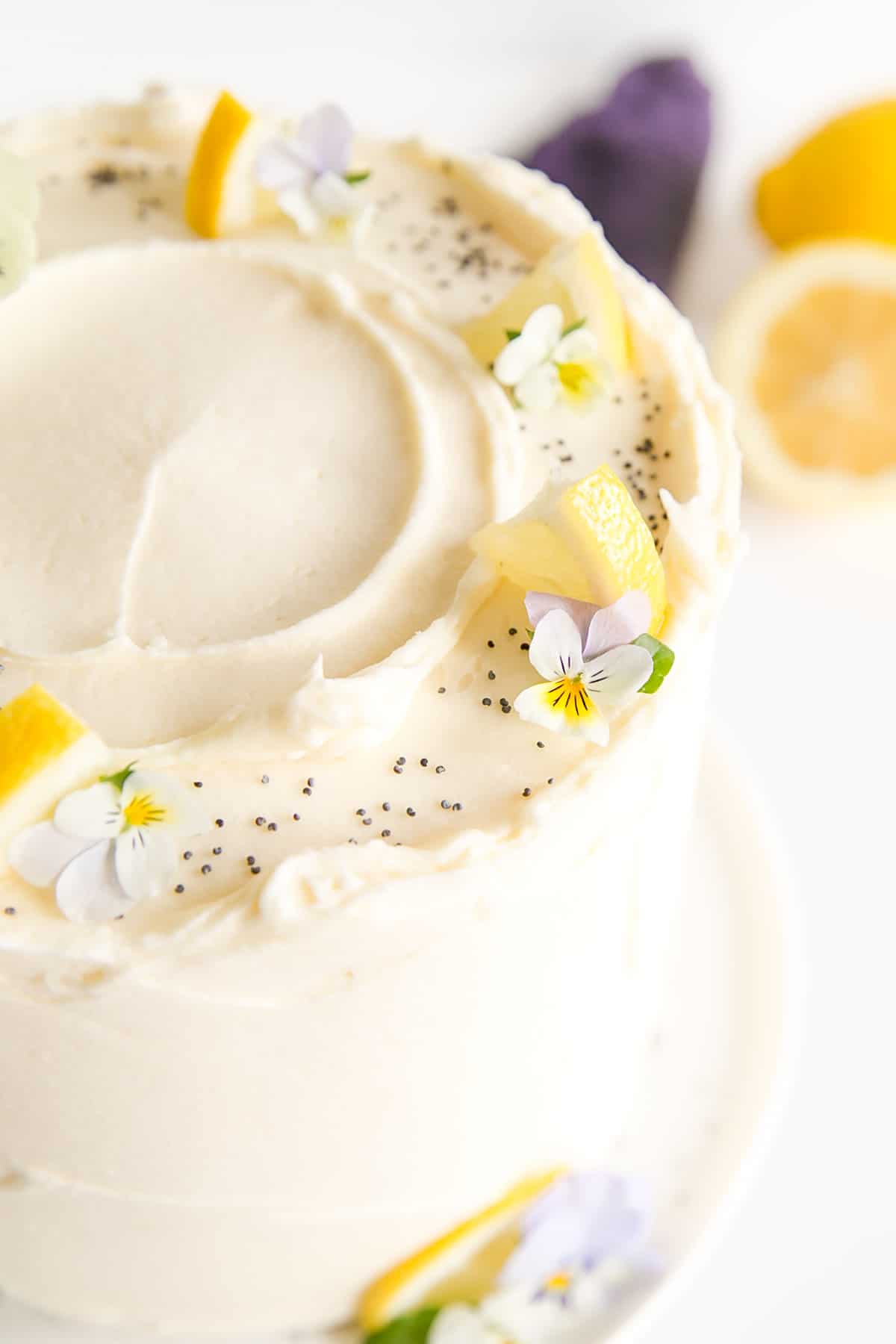 Close up of the lemon slices and pansies on the top of the cake.