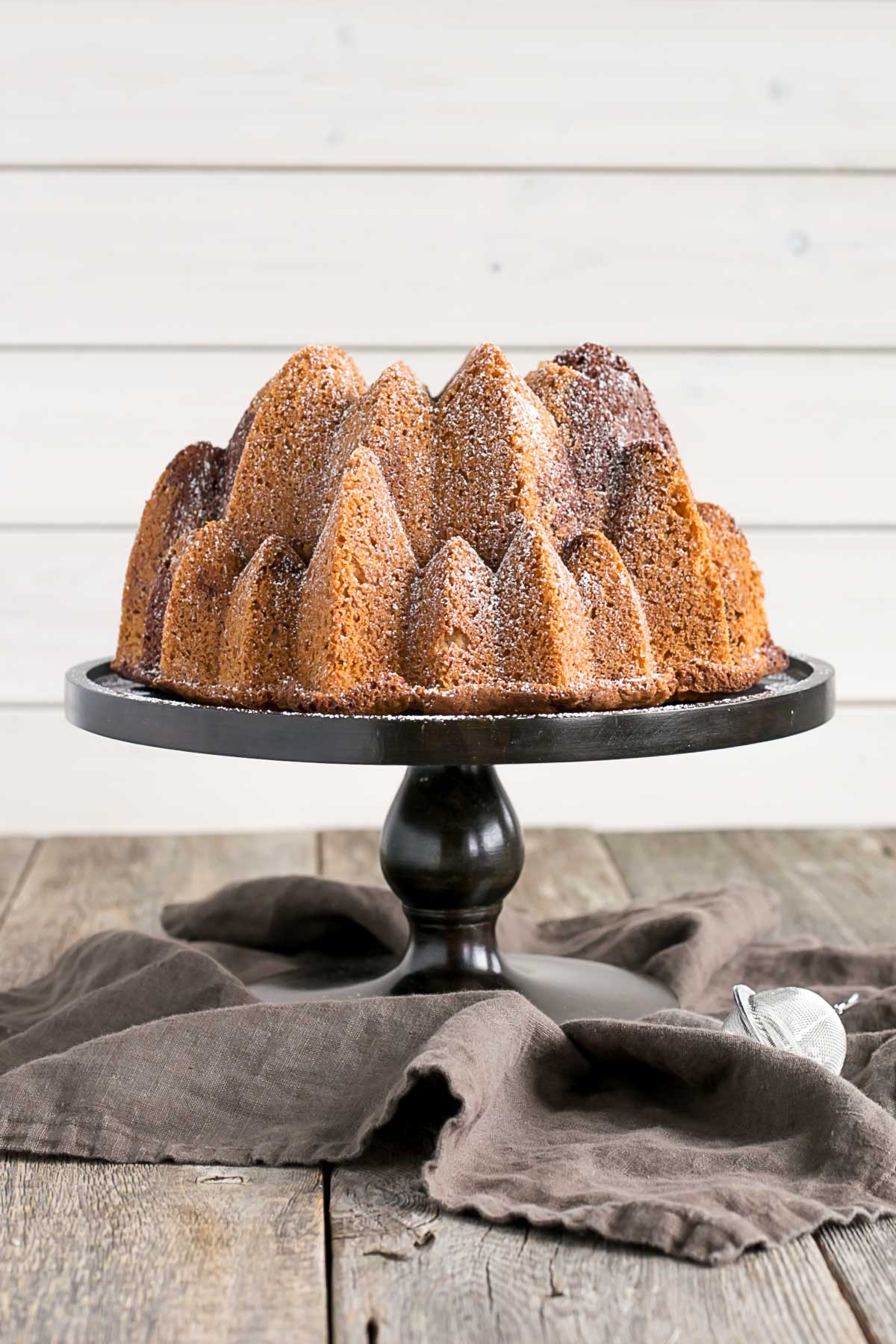 Bundt cake on a wooden cake stand.