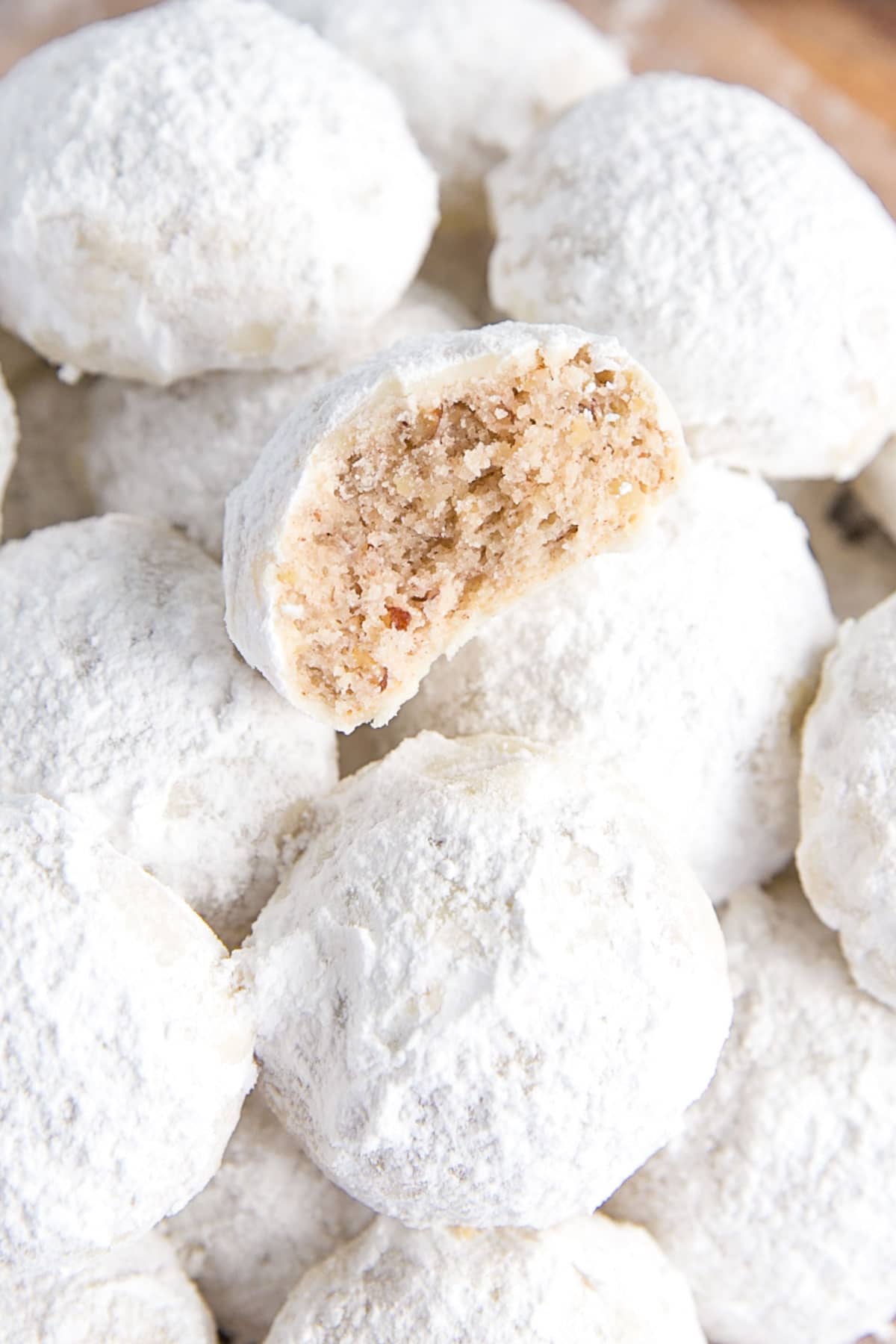 Close up of half of a mexican wedding cookie on a stack.