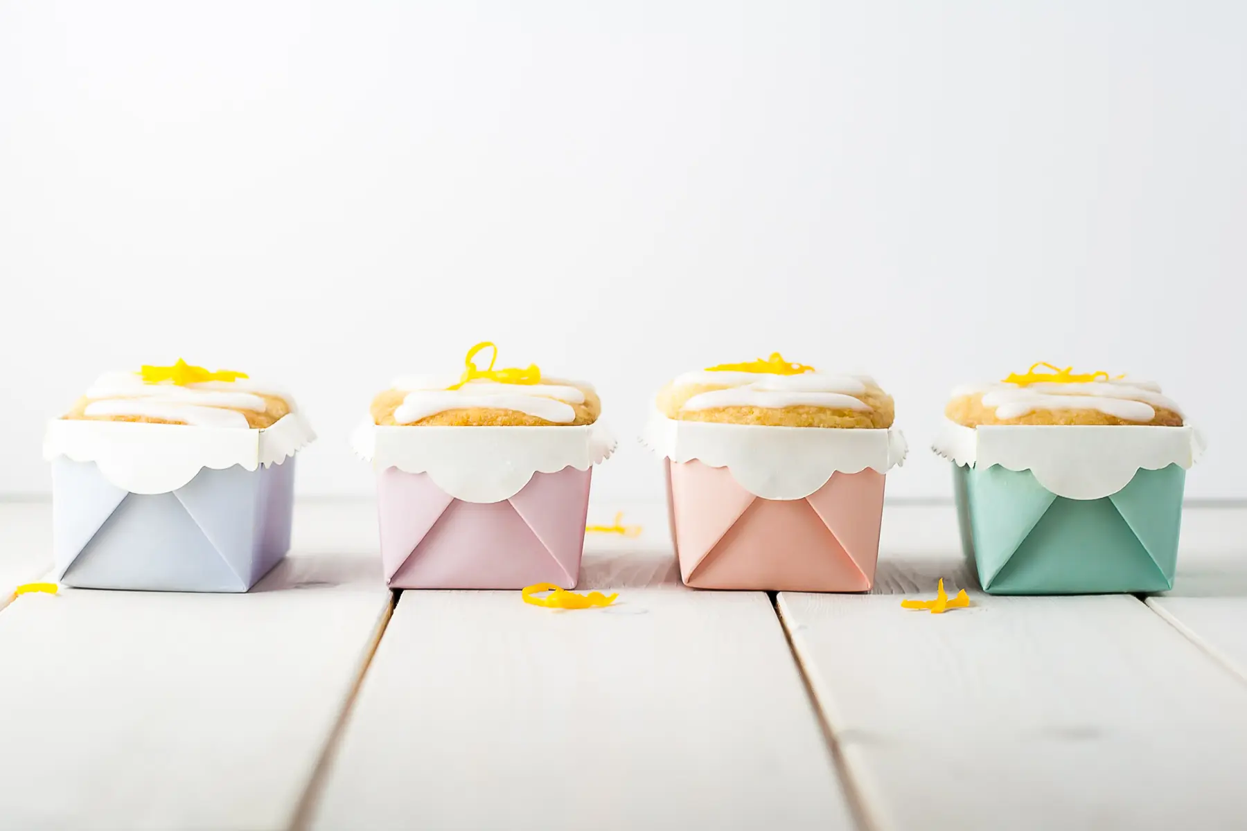 Four mini lemon loaves in pastel liners.