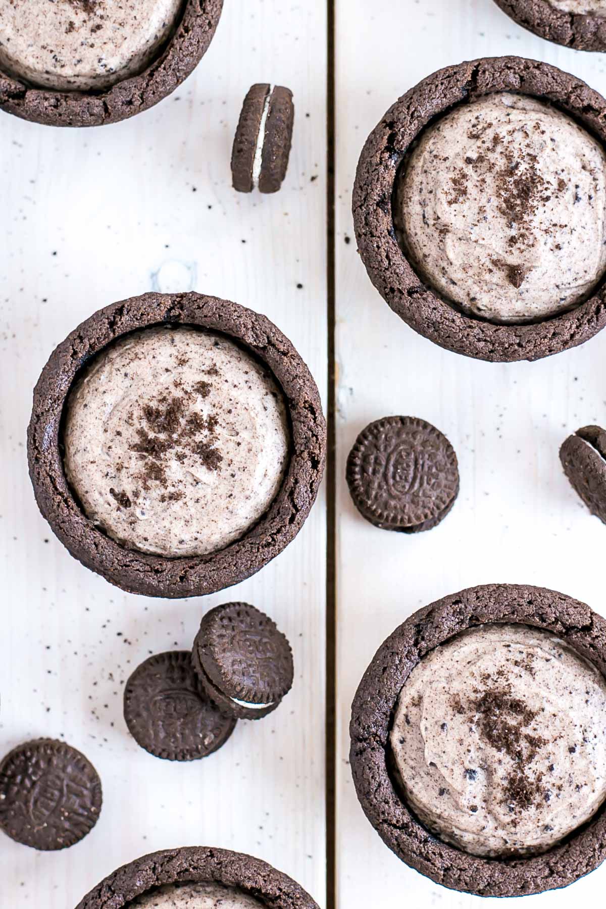 Overhead shot of cookie cups on a white wood background.