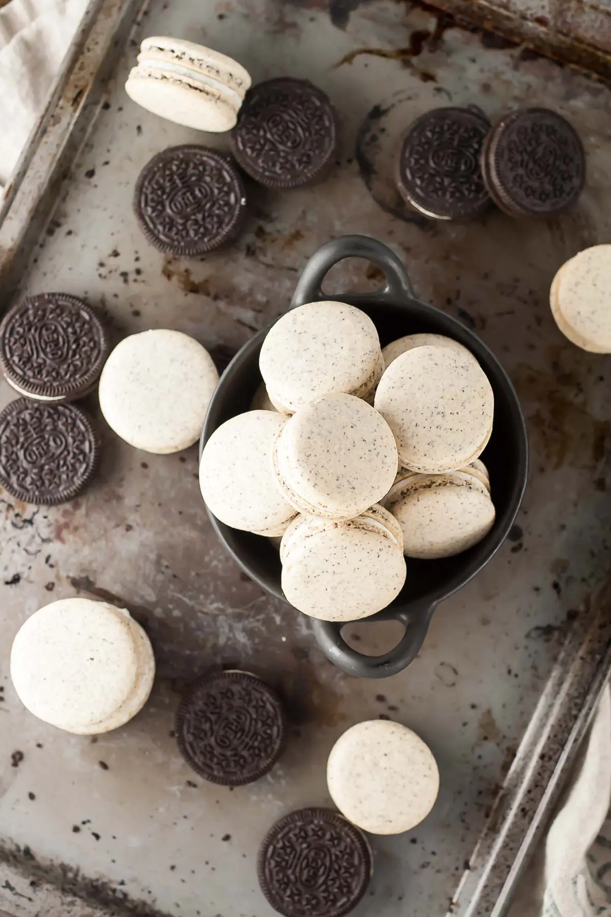 Overhead image of oreo macarons on a baking sheet.