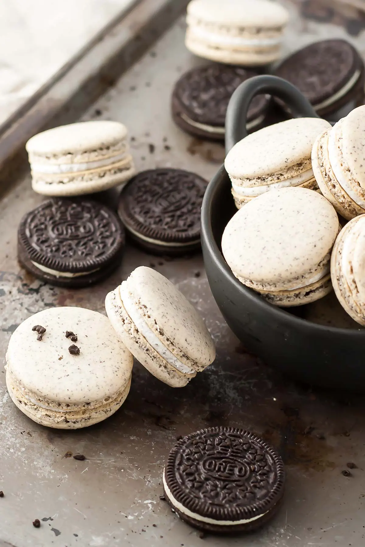 Oreo macarons and Oreo cookies on a baking sheet.