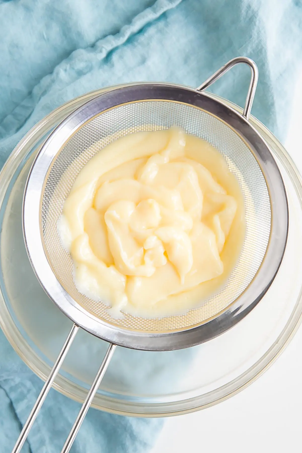 Passing the custard through a strainer.