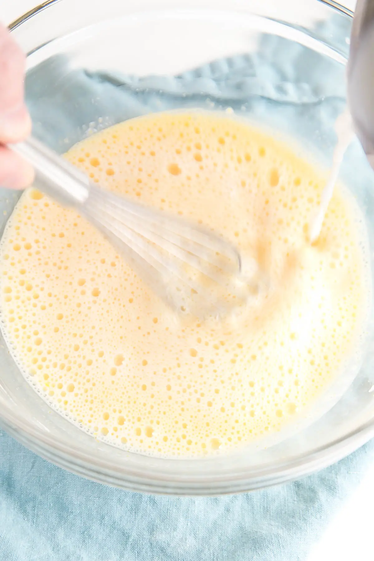 Egg mixture being tempered with hot milk.