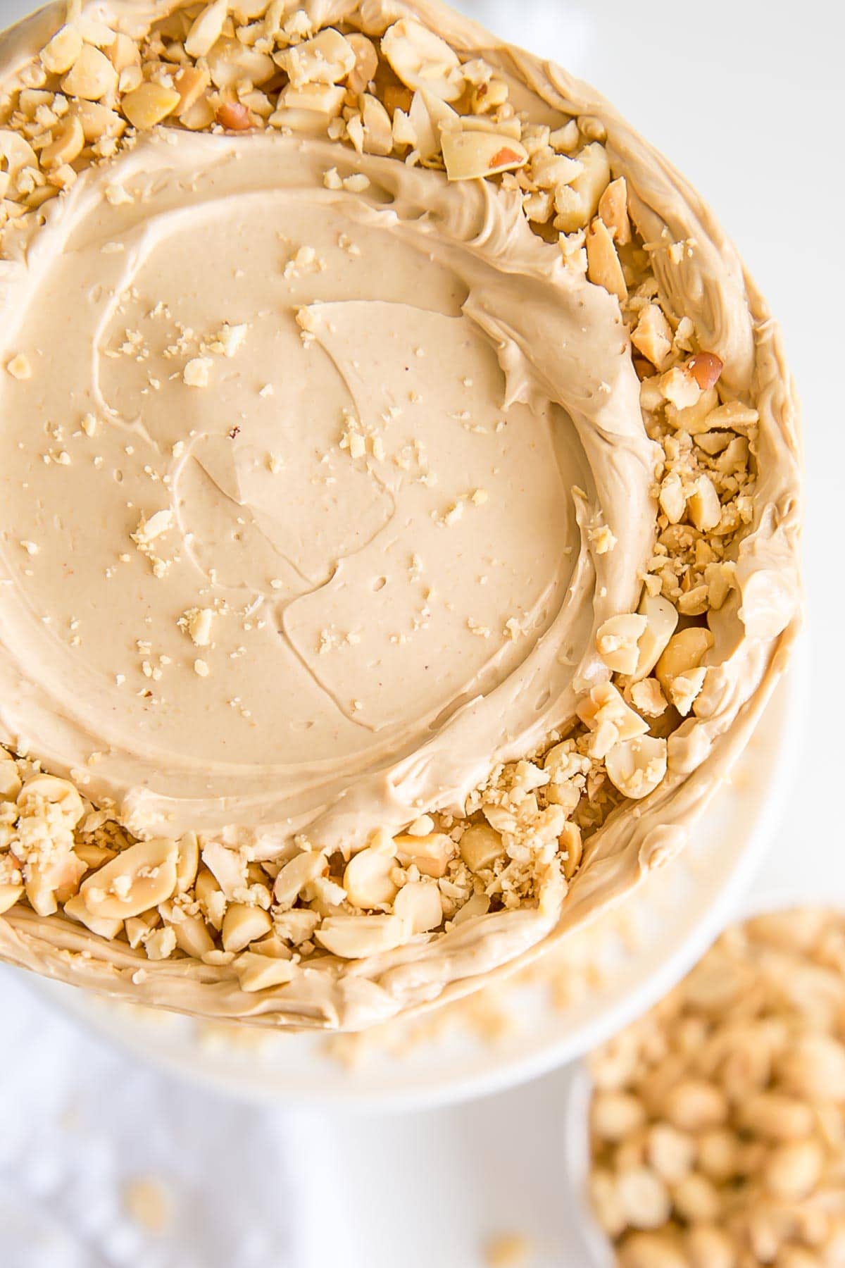 Top view of the cake showing fresh chopped peanuts and a rustic frosting.