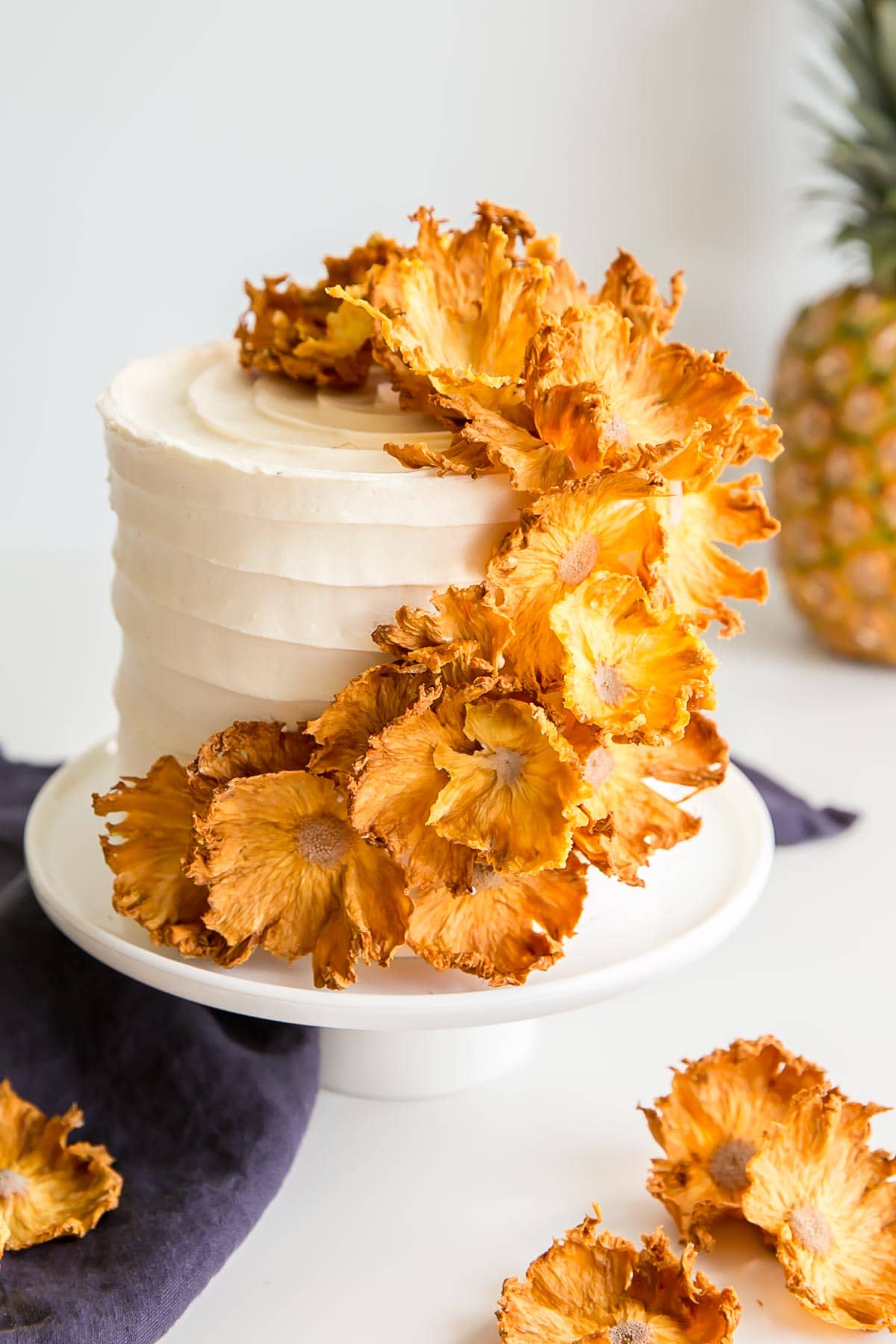 Angled shot of a Pineapple Cake with pineapple flowers cascading down the side.