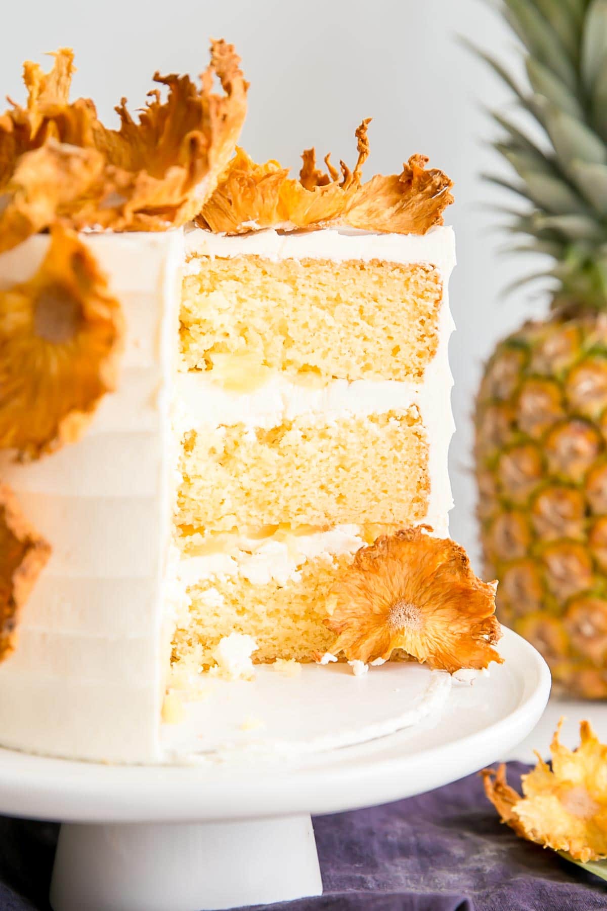 Pineapple cake with some slices cut out showing the cake layers.