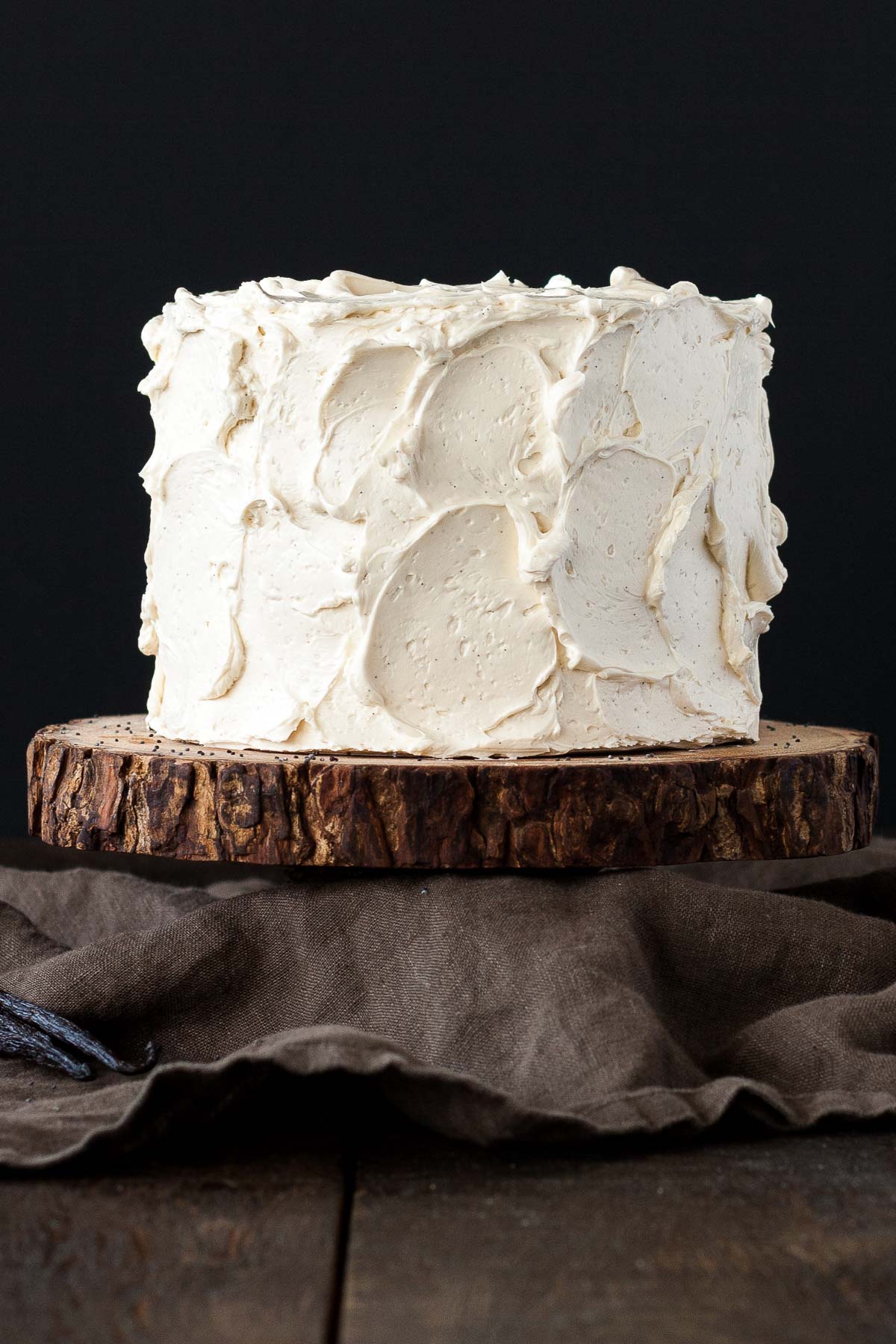 Cake on top of a rustic wood cake stand.