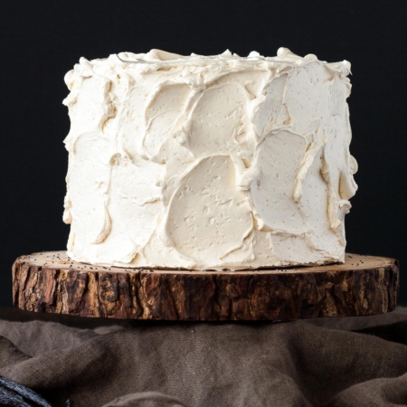 Cake on top of a rustic wood cake stand.