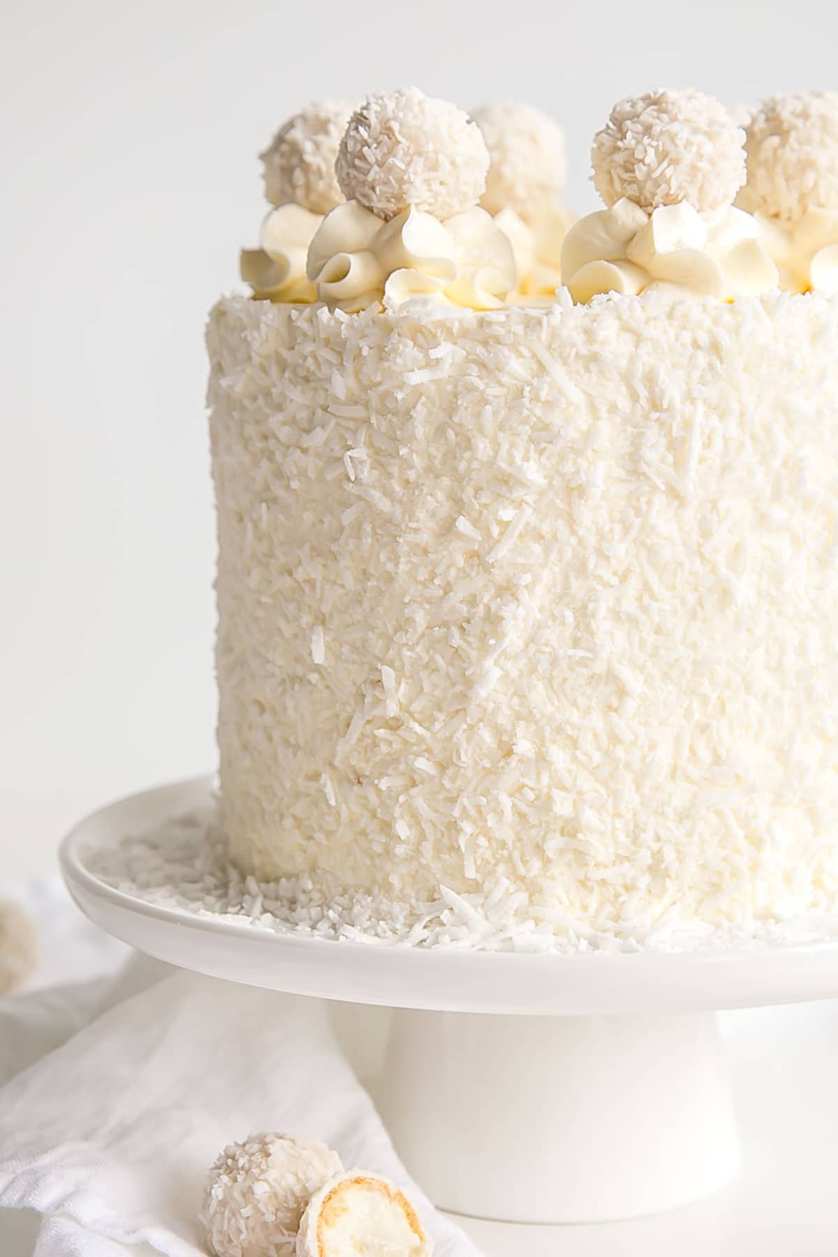 Close up of a coconut almond cake with Raffaello's on top.