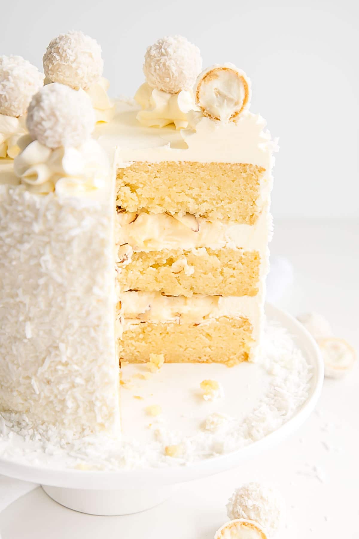 Cross section of a Raffaello Cake with almond cake layers and coconut cream custard.