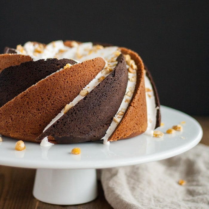 Rocky road bundt cake on a white cake stand.