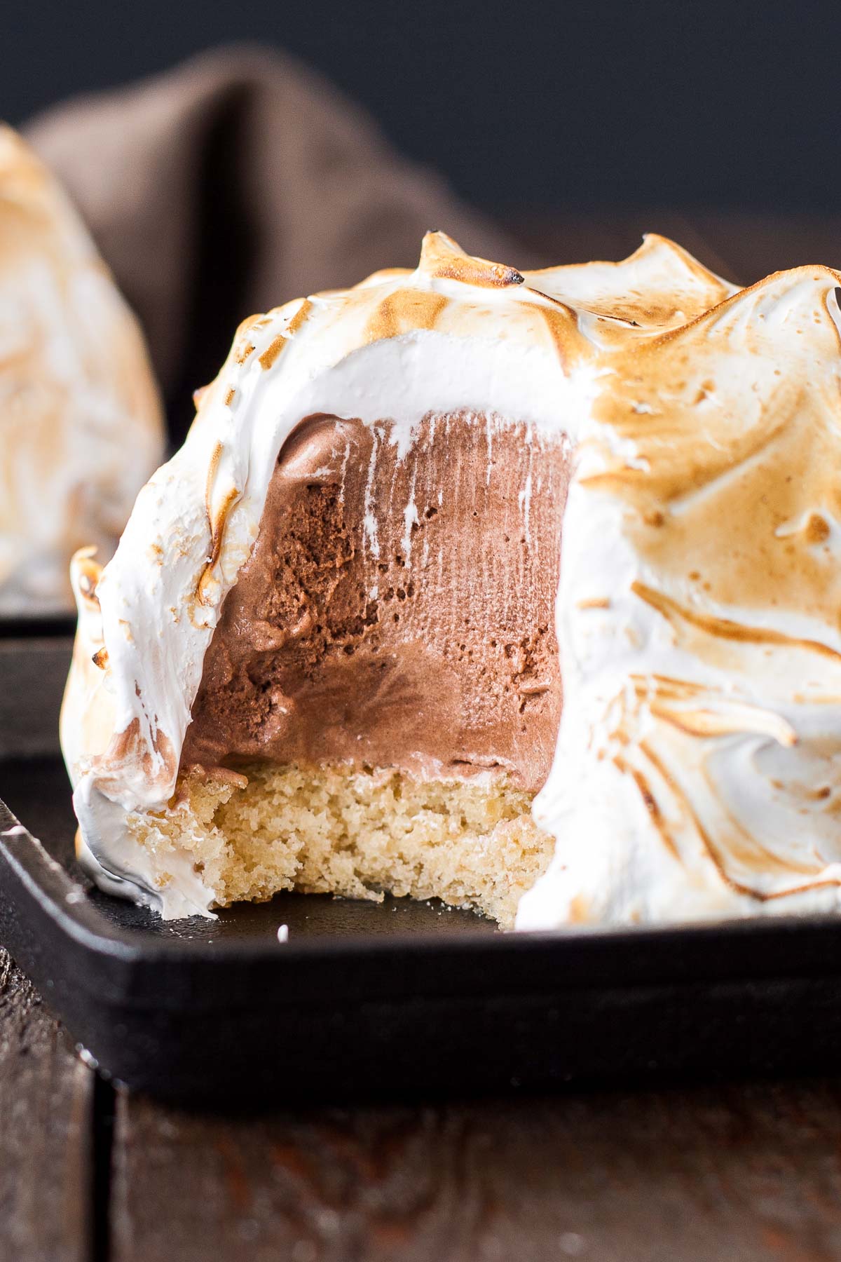 A close up of a baked alaska with a bite taken out.