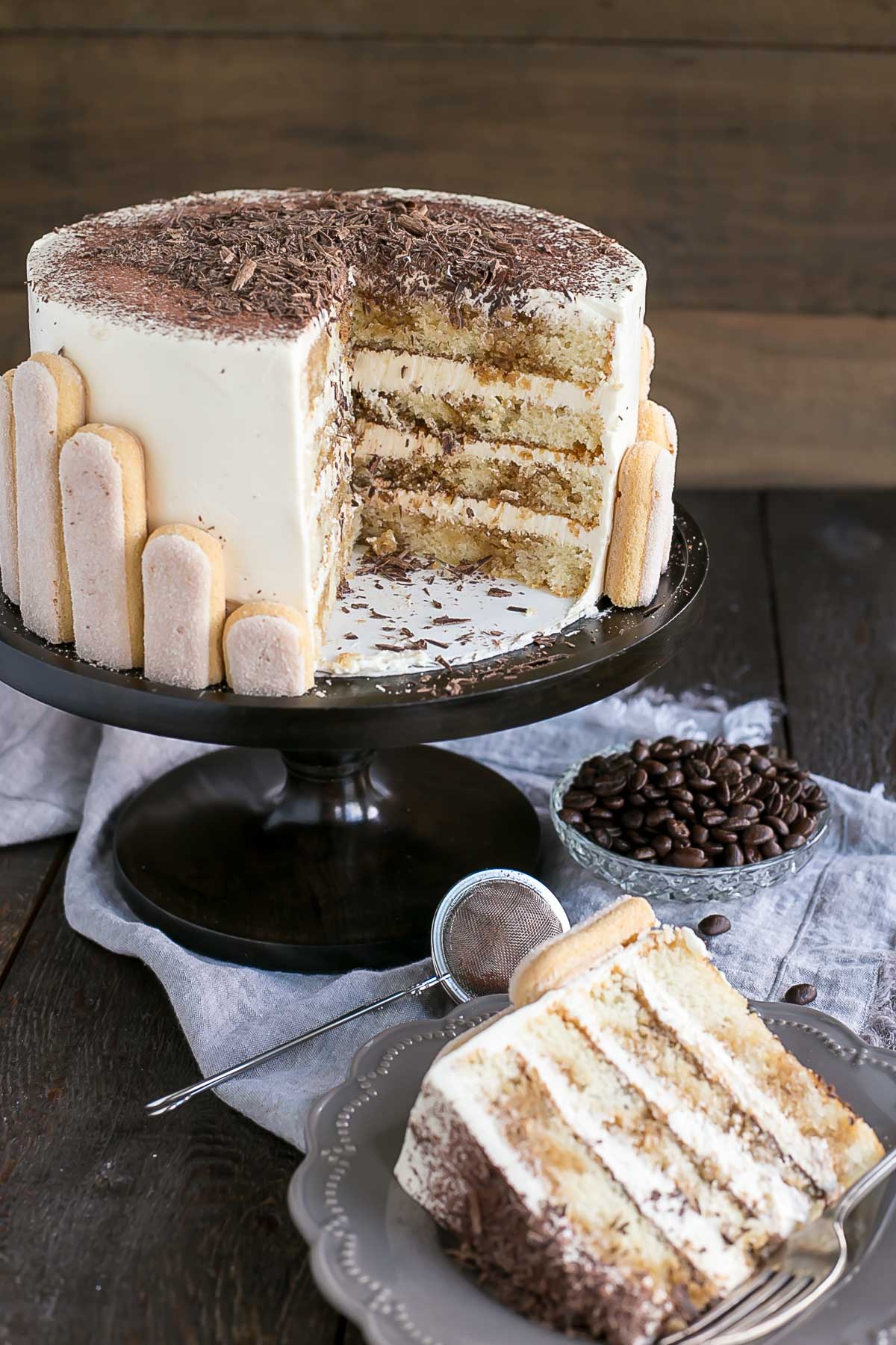 A slice of cake on a plate with a cross section of the cake behind it.