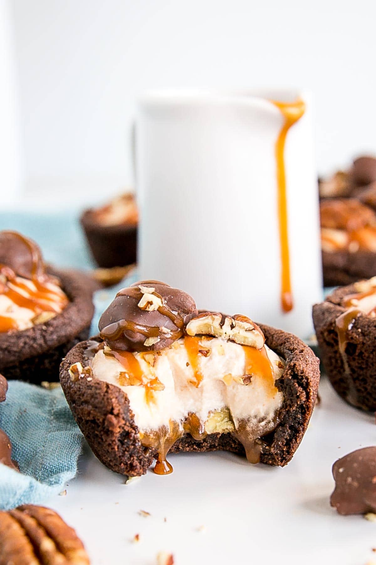 Turtle Cookie Cups with a bite taken out showing caramel oozing out.