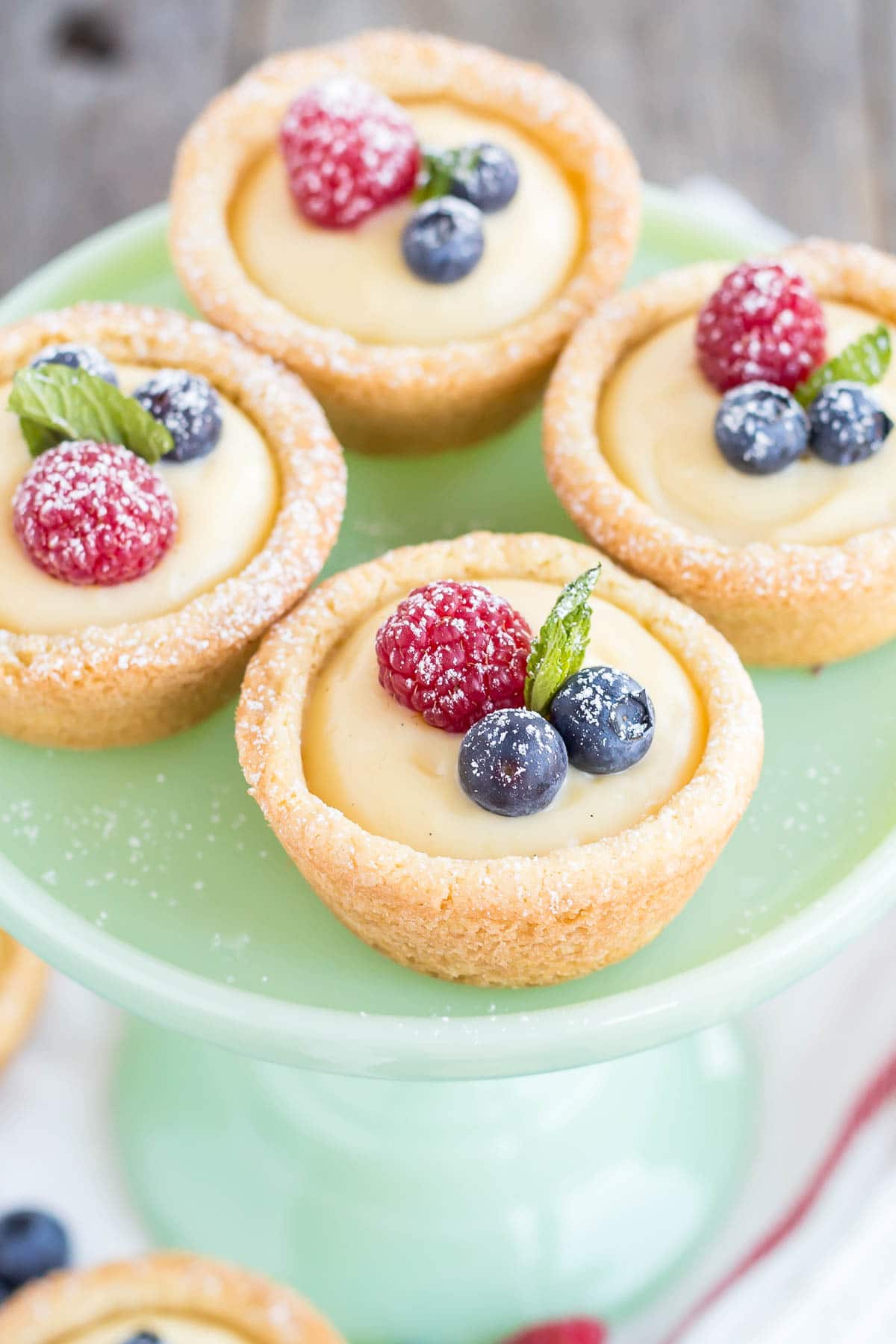 A close up the cookie cups on a mint green cake stand.